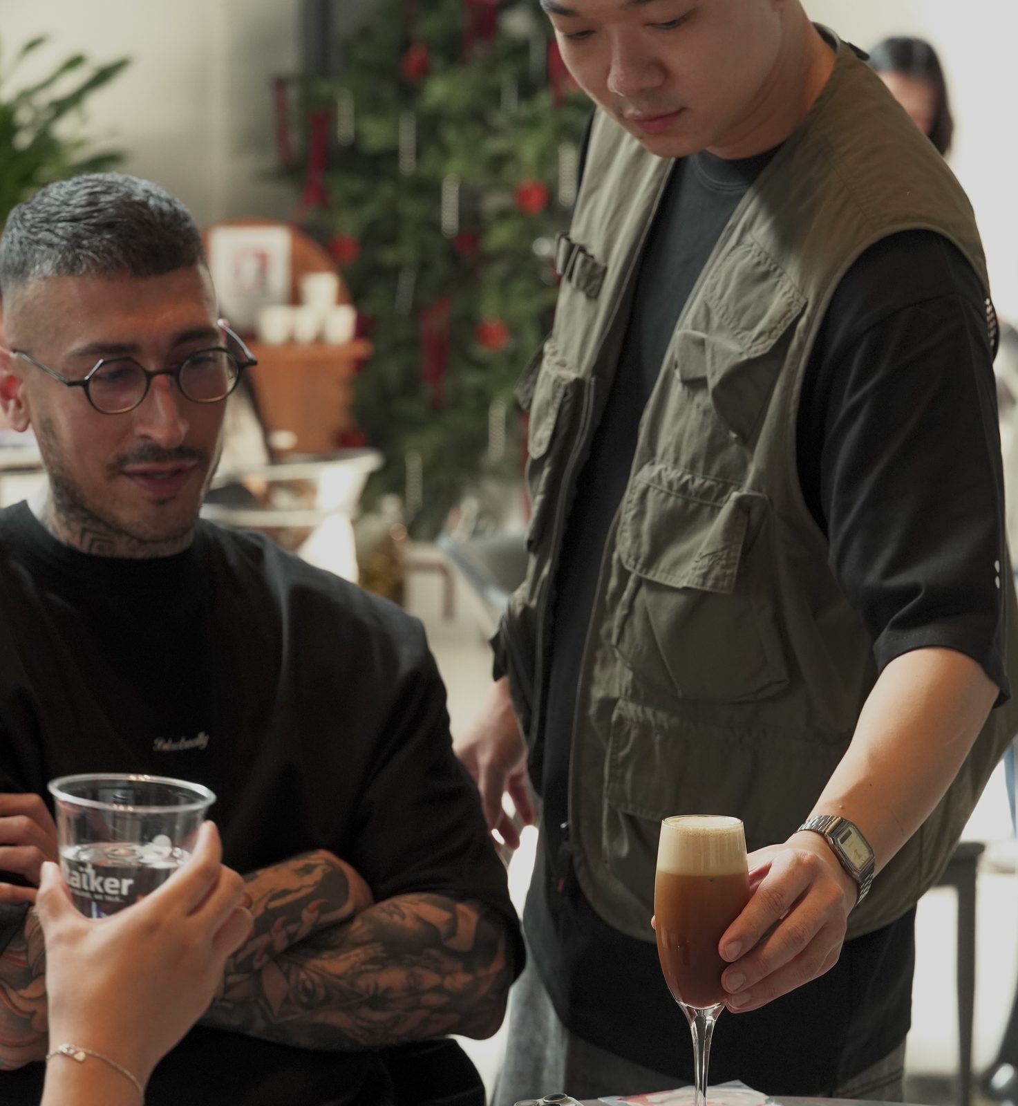 Two friends talking over taïker coffees at a café table.