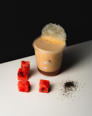 An iced taïker drink topped with foam.