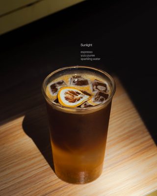 A tall glass of taïker yuzu coffee over ice.